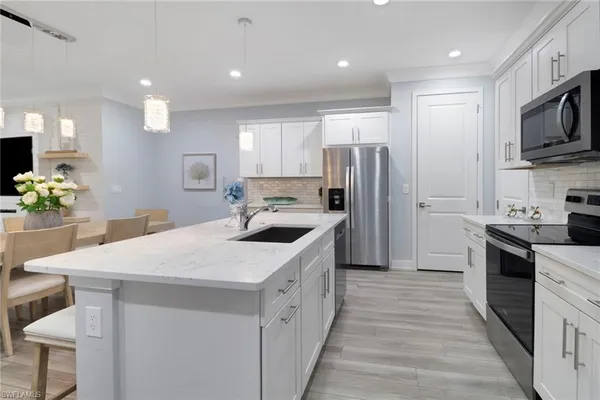 a kitchen with a sink a counter top space stainless steel appliances and cabinets