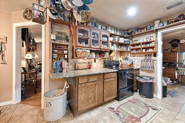 a kitchen with stainless steel appliances kitchen island granite countertop a refrigerator oven a sink and dishwasher