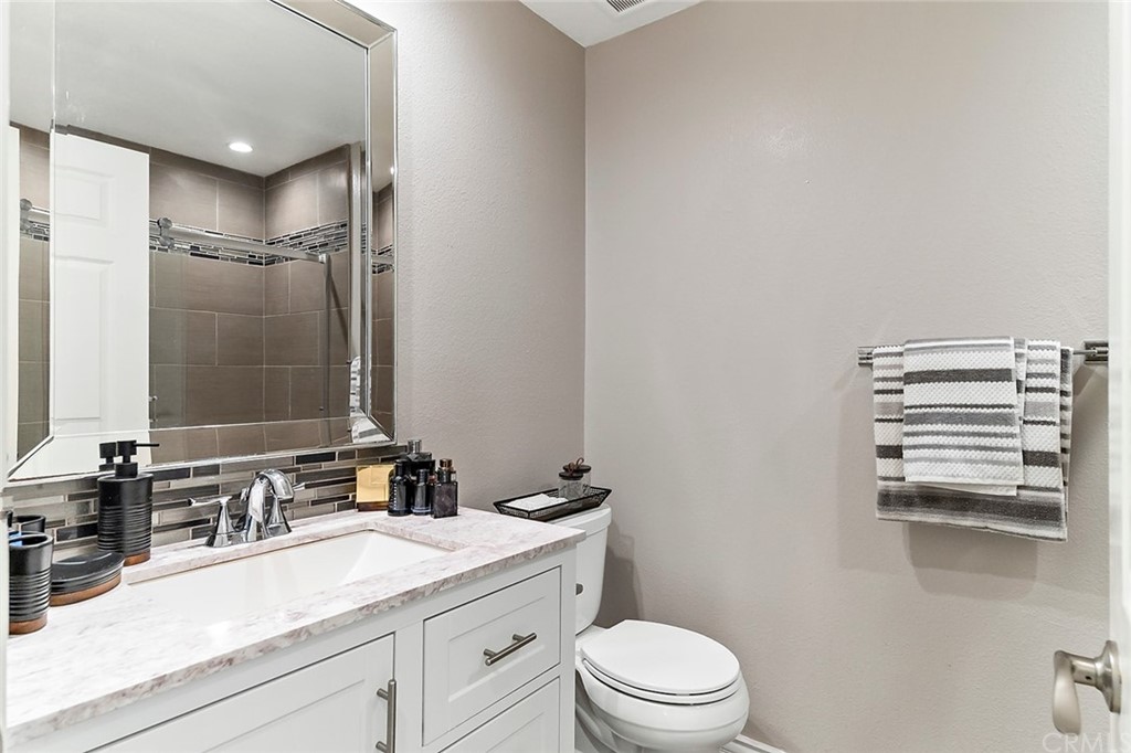 20301 Bluffside Circle, Unit 304 Huntington Beach, CA 92646 - Photo 24 of 40 a bathroom with a granite countertop sink mirror vanity and toilet