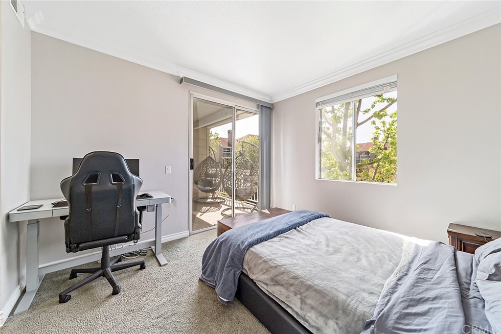 20301 Bluffside Circle, Unit 304 Huntington Beach, CA 92646 - Photo 26 of 40 a bedroom with a bed a table and a window