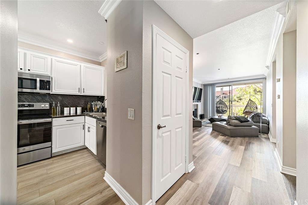 20301 Bluffside Circle, Unit 304 Huntington Beach, CA 92646 - Photo 4 of 40 a kitchen with sink a refrigerator and a stove top oven