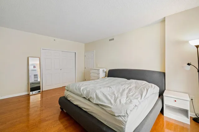 a bedroom with a bed and wooden floor
