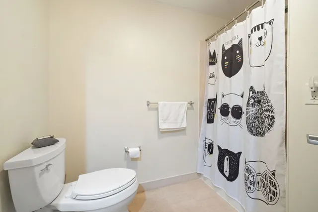 a white toilet sitting next to a white wall