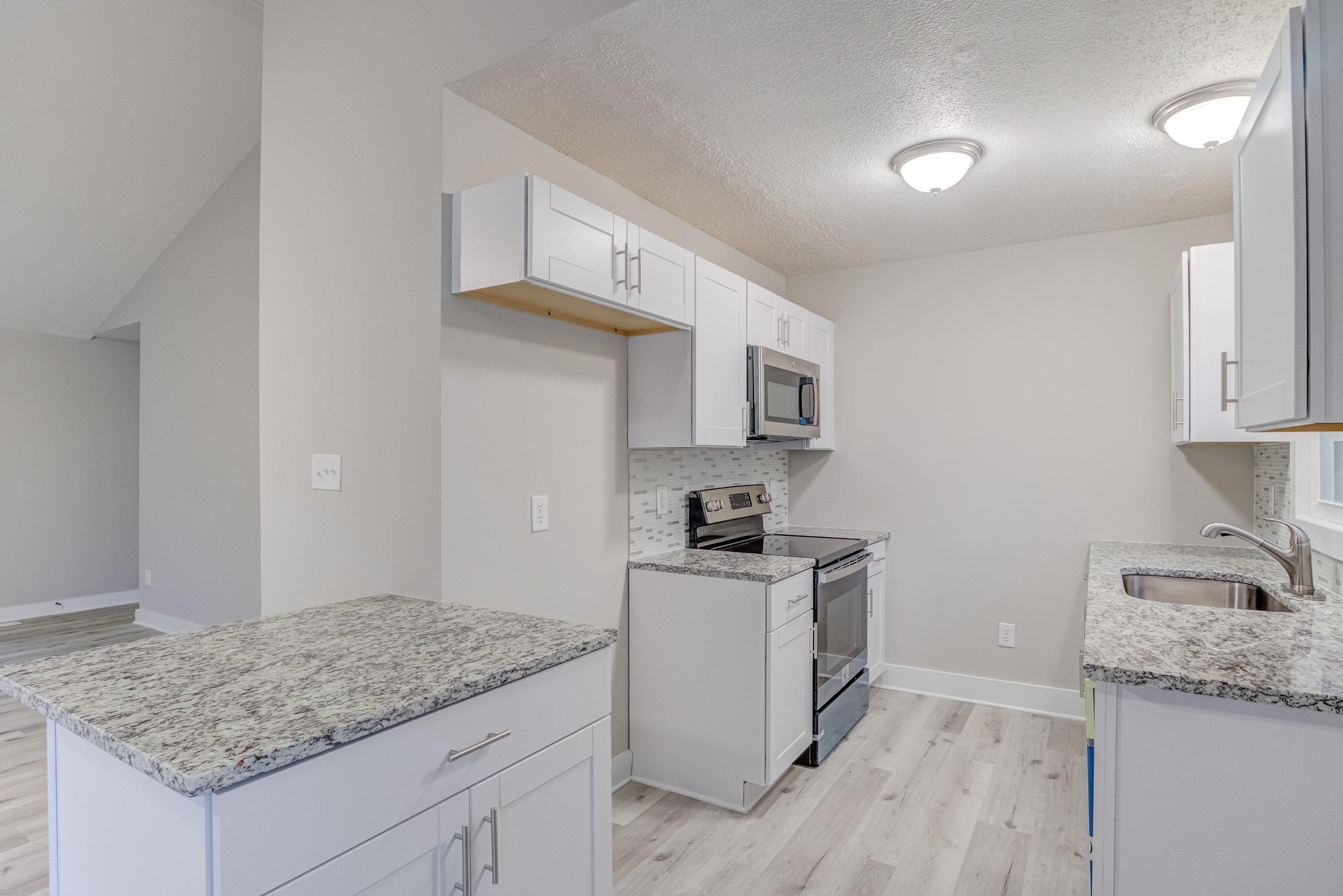 5404 Pear Orchard Lane Raleigh, NC 27616 - Photo 6 of 22 a kitchen with granite countertop white cabinets and white appliances