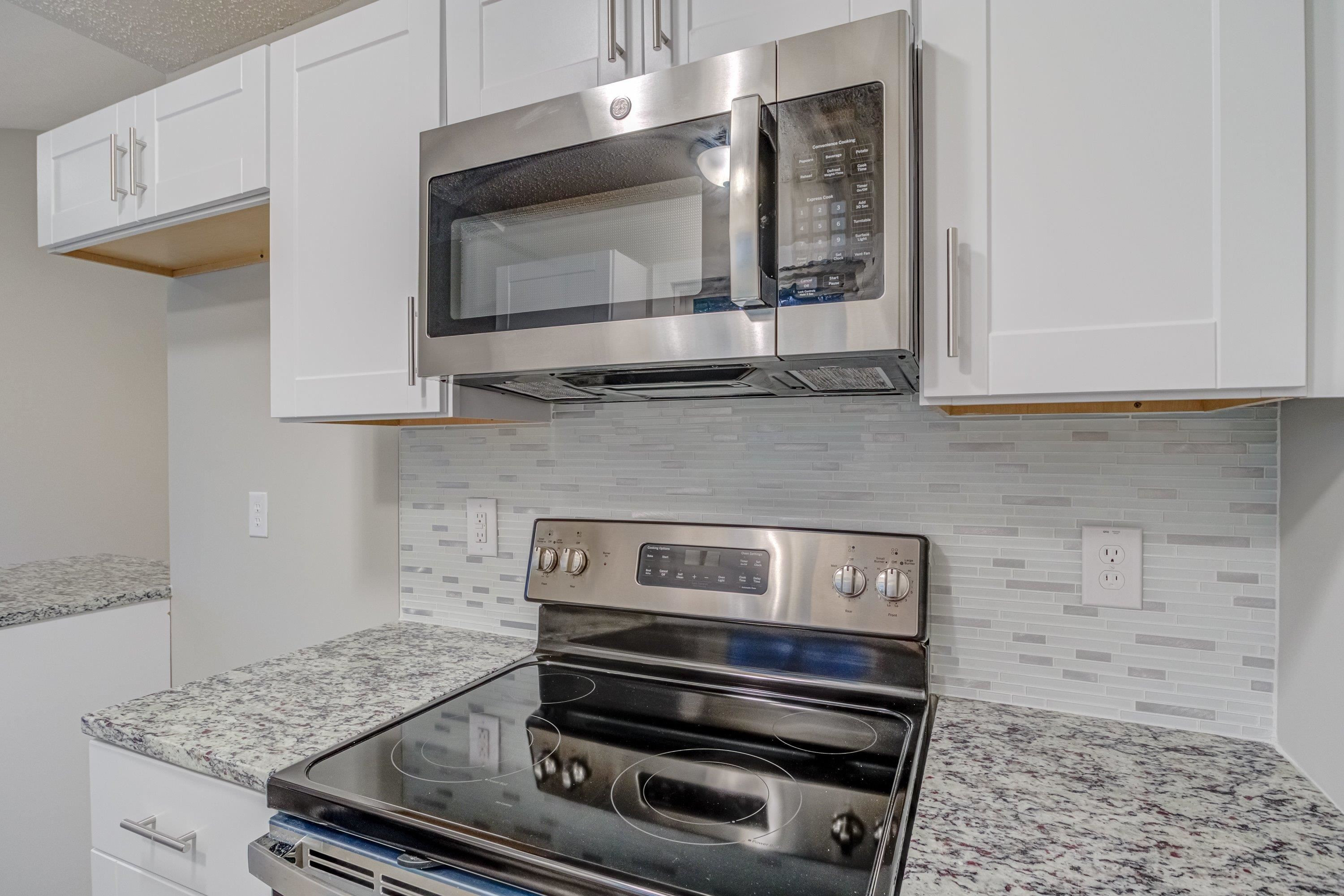 5404 Pear Orchard Lane Raleigh, NC 27616 - Photo 8 of 22 a kitchen with a stove and a microwave