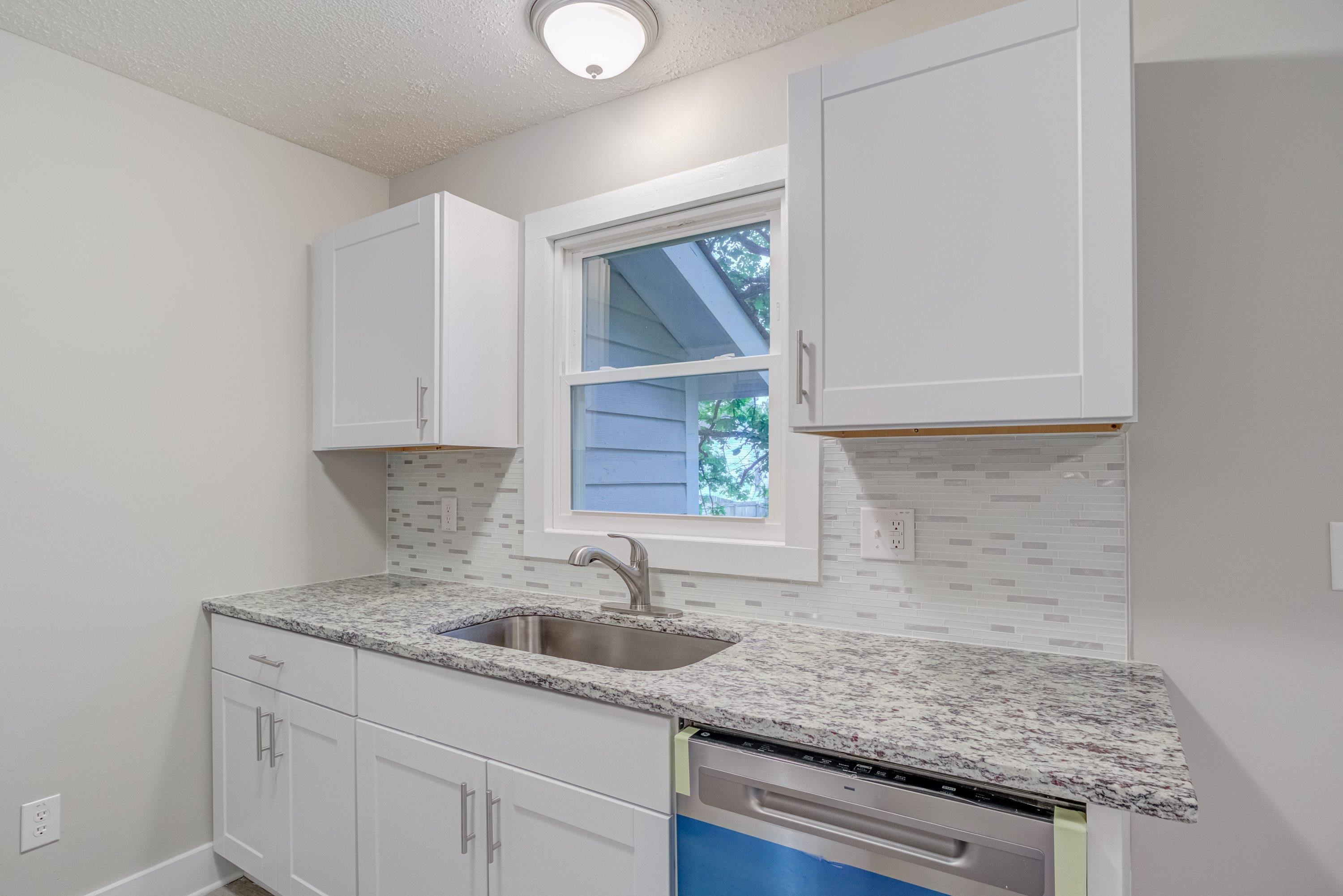 5404 Pear Orchard Lane Raleigh, NC 27616 - Photo 9 of 22 a kitchen with granite countertop a sink and cabinets
