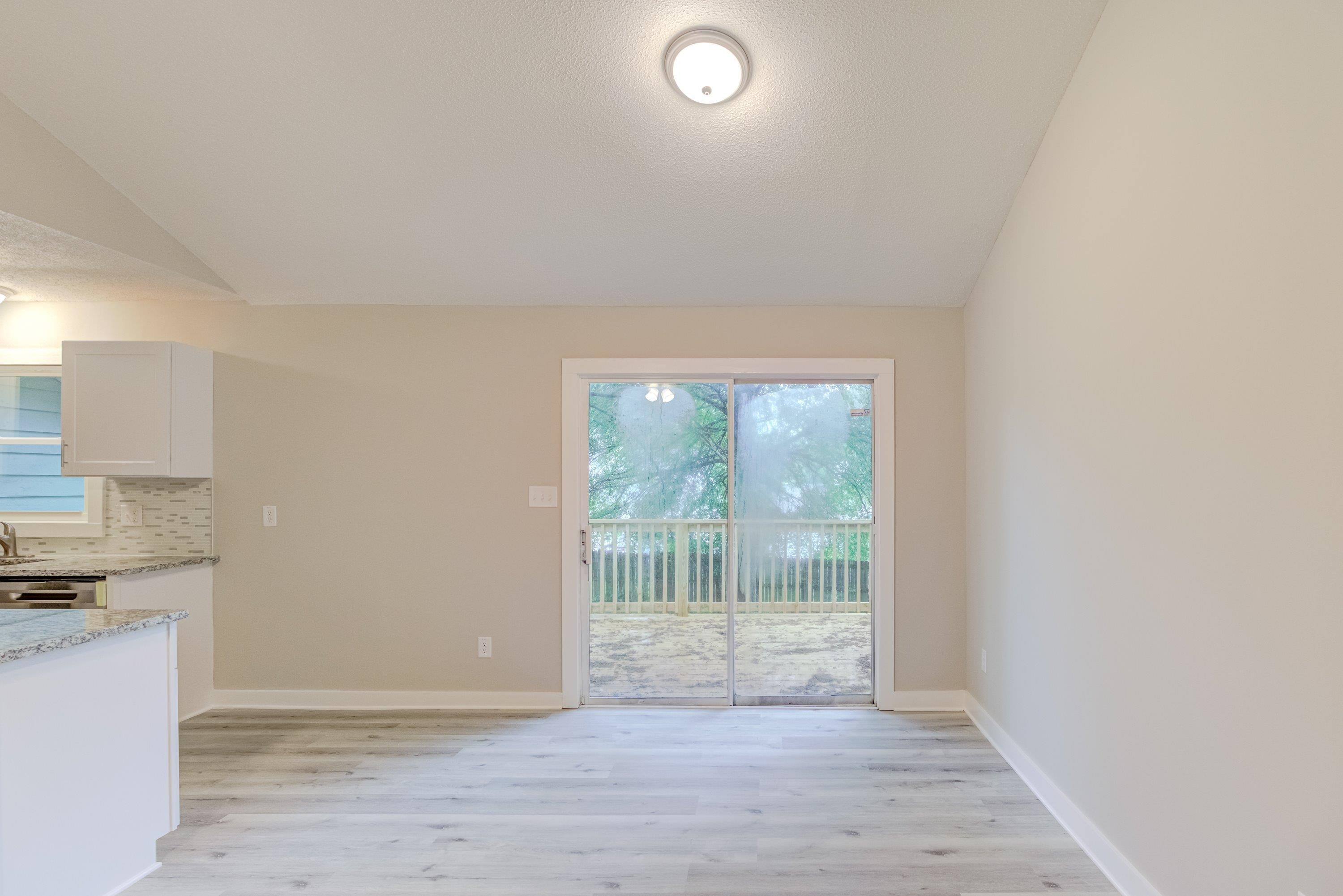 5404 Pear Orchard Lane Raleigh, NC 27616 - Photo 10 of 22 an empty room with wooden floor and windows