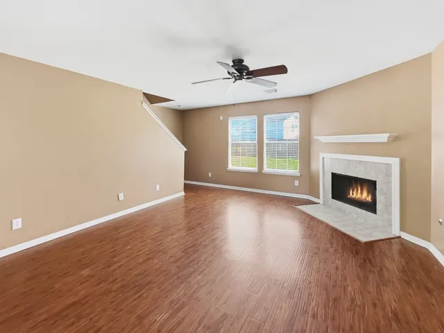 a view of empty room with wooden floor and fireplace