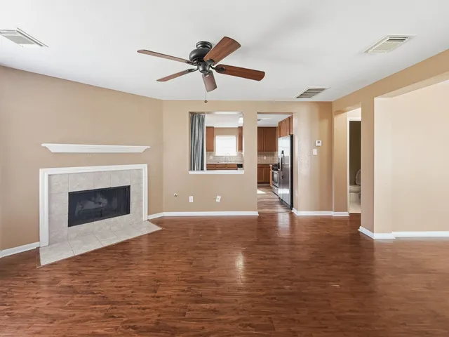 a view of an empty room with window and fire place