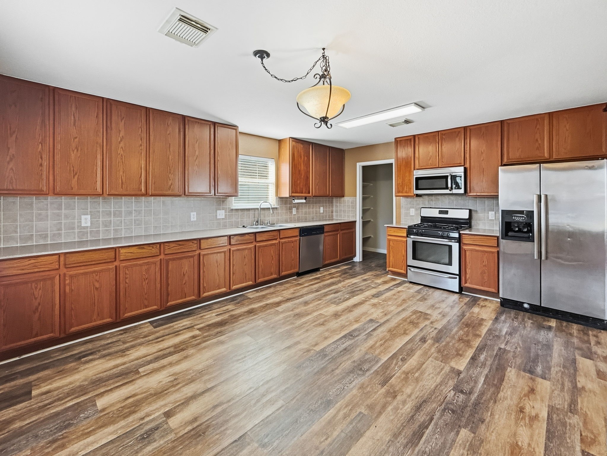 29502 Legends Pine Lane Spring, TX 77386 - Photo 5 of 15 a large kitchen with stainless steel appliances granite countertop a stove top oven a refrigerator a sink and dishwasher with wooden floor