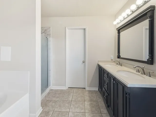 a bathroom with a double vanity sink and a mirror