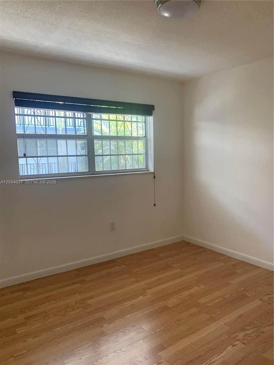 2460 Southwest 18th Avenue, Unit 1205 Miami, FL 33133 - Photo 15 of 21 wooden floor in an empty room with a window