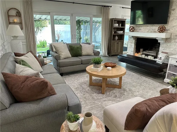 a living room with furniture a flat screen tv and a fireplace