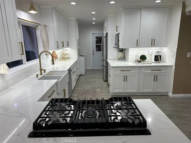 a kitchen with cabinets stainless steel appliances and wooden floor