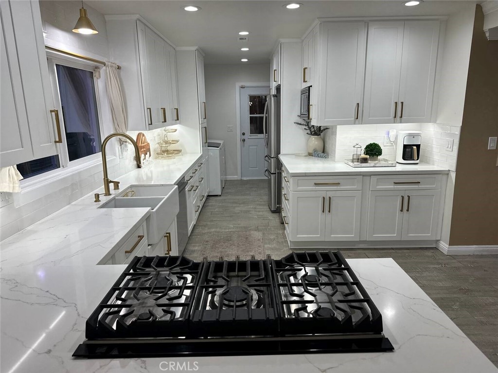 12280 Caladre Avenue Downey, CA 90242 - Photo 3 of 15 a kitchen with kitchen island granite countertop a sink stove and refrigerator