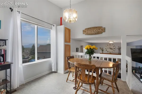 a view of a dining room with furniture and chandelier