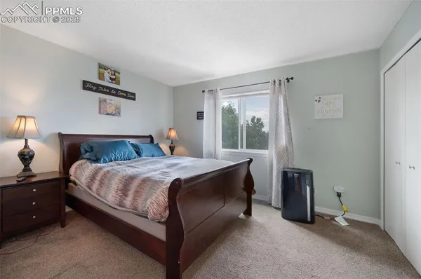 a bedroom with a bed and a lamp next to a window