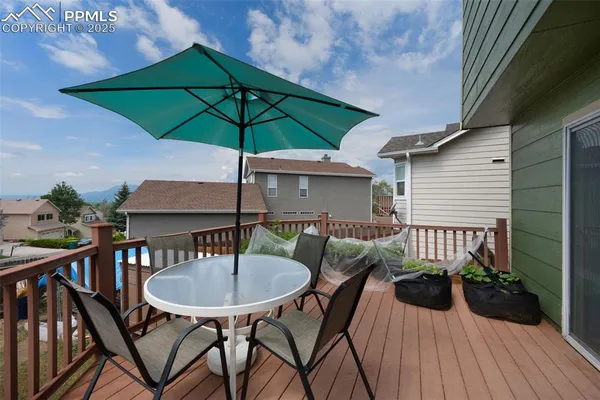 a table and chairs in patio of blue umbrella