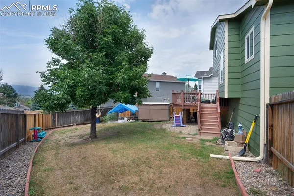 a view of a house with a backyard and a large tree