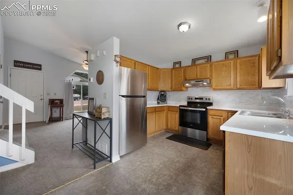 a kitchen with granite countertop a sink cabinets and stainless steel appliances