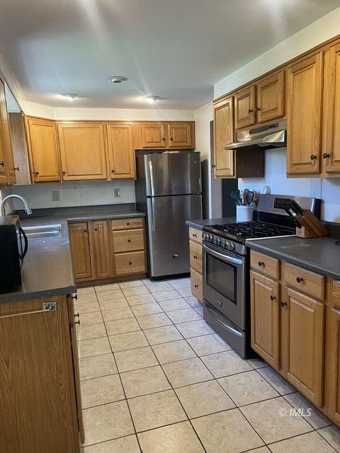 103 North Clay Street Independence, CA 93526 - Photo 5 of 25 a kitchen with a sink a stove and refrigerator