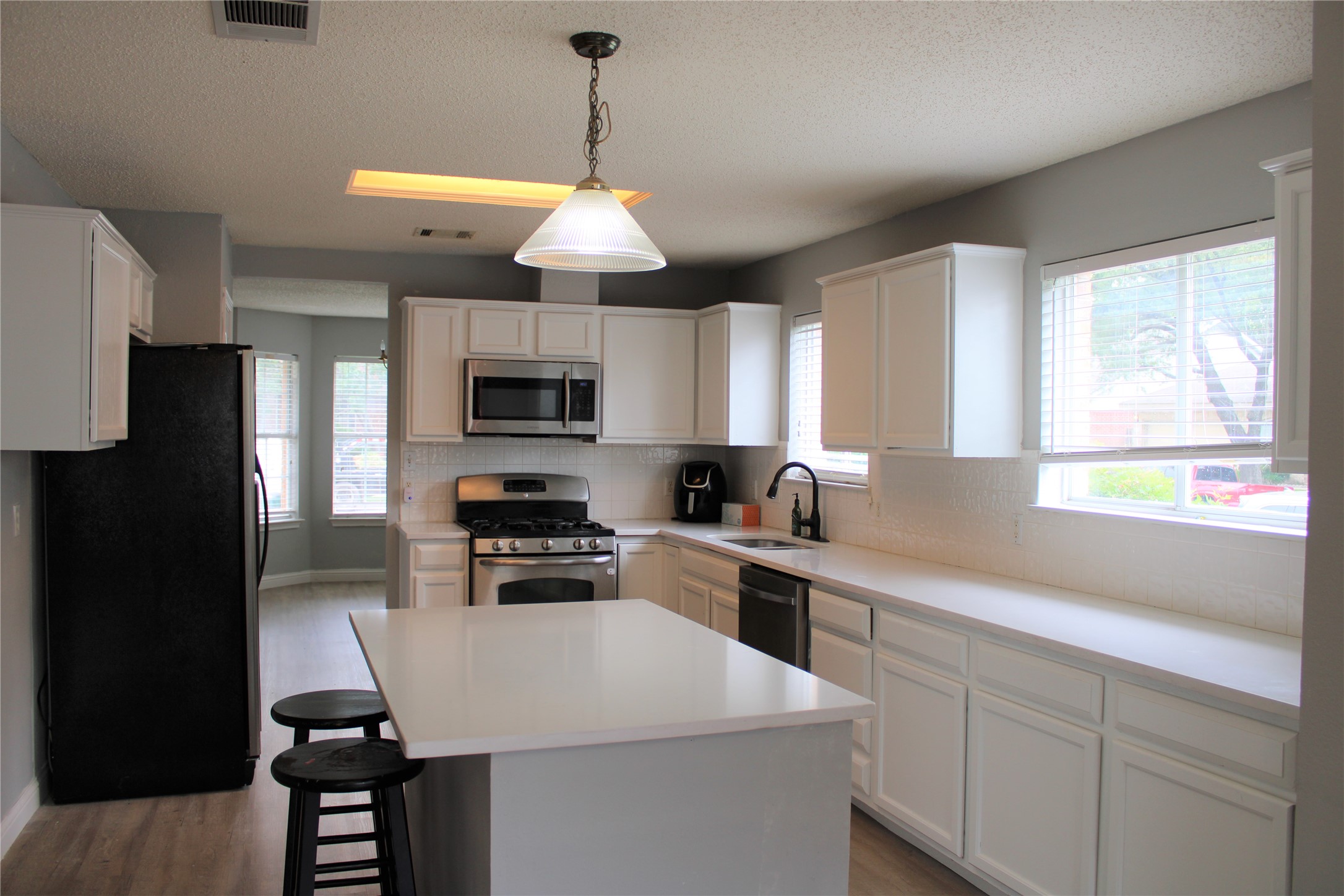 16205 Glorious Lane Pflugerville, TX 78660 - Photo 6 of 30 a kitchen with a stove a sink and a refrigerator