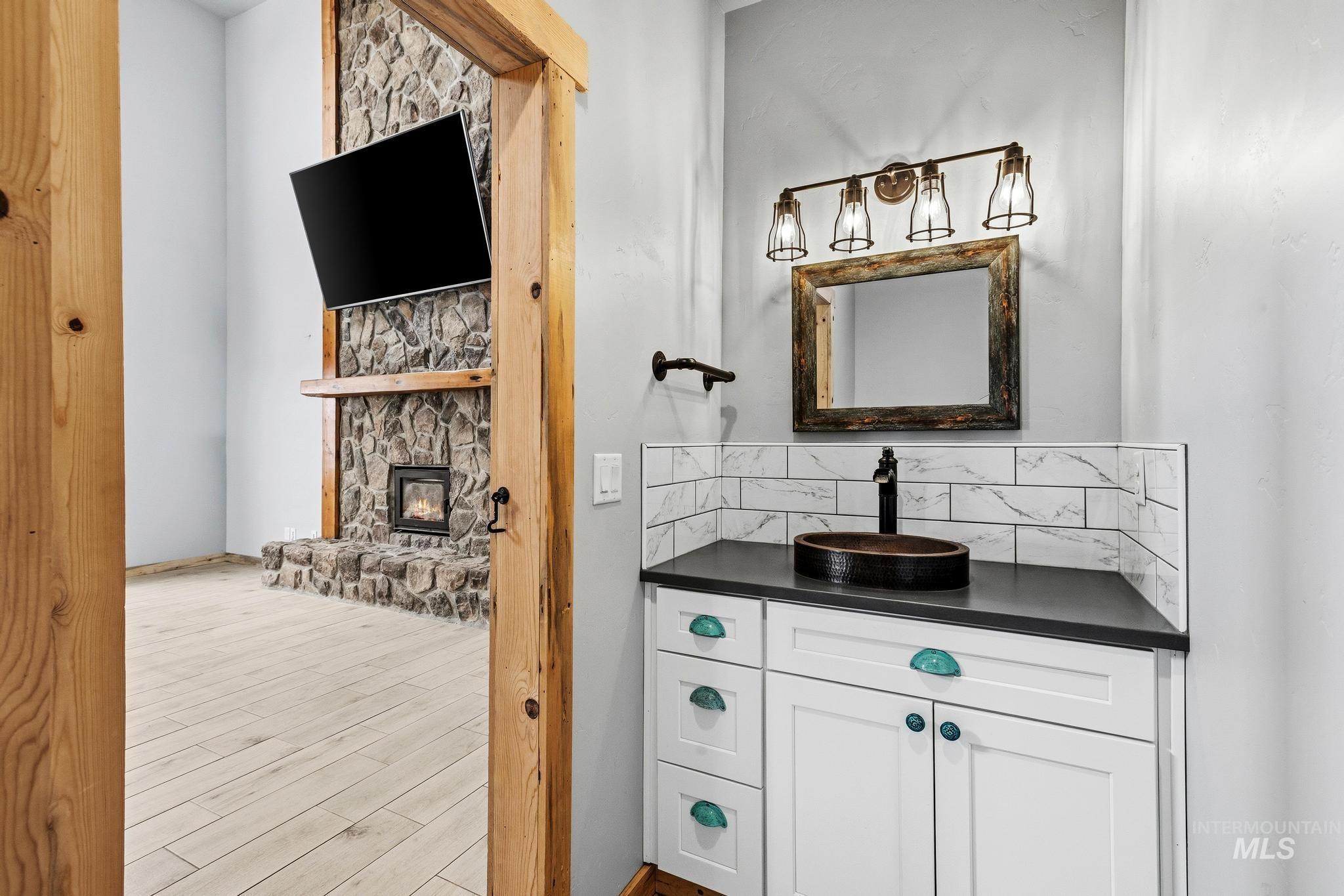870 Desert Wind Road Boise, ID 83716 - Photo 26 of 50 Spacious loft area featuring light wood-finish flooring, a wall-mounted display, and a decorative railing system with wood accents and black balusters