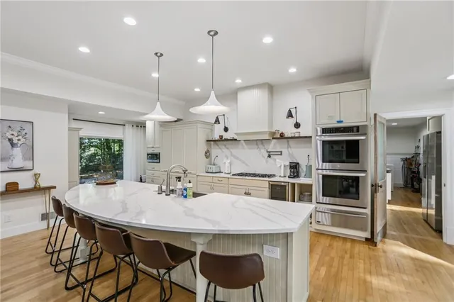 a kitchen with kitchen island a dining table and chairs