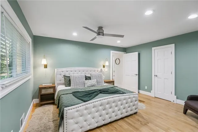 a bedroom with a large bed and a chandelier