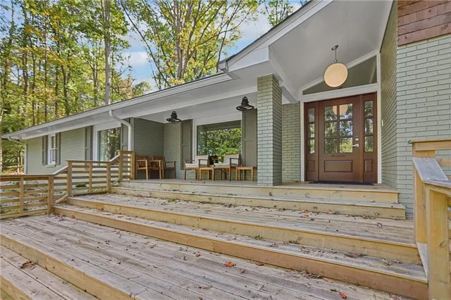 a view of a house with entrance stairs and a tree