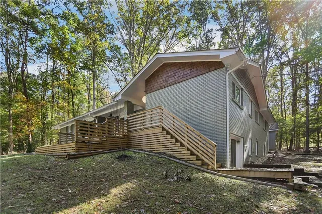 a backyard of a house with wooden fence and large trees