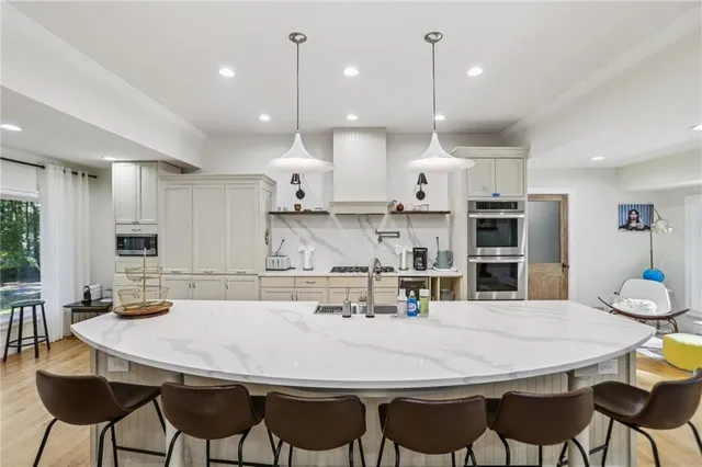 a kitchen with stainless steel appliances kitchen island granite countertop a kitchen island and chairs in it