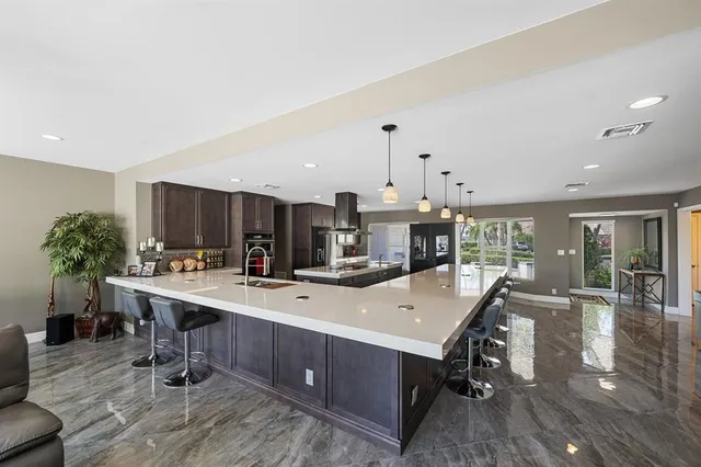 a kitchen with kitchen island granite countertop lots of counter top space and stainless steel appliances