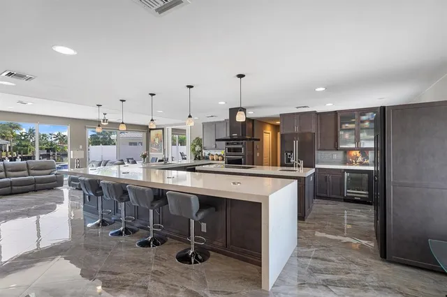a kitchen with stainless steel appliances granite countertop a sink a stove and a refrigerator