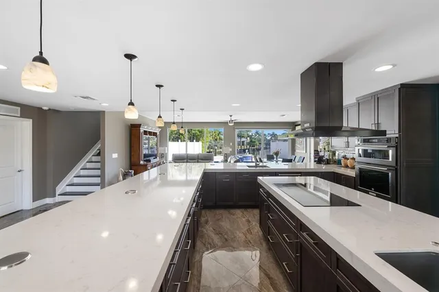 a large kitchen with stainless steel appliances a large counter top