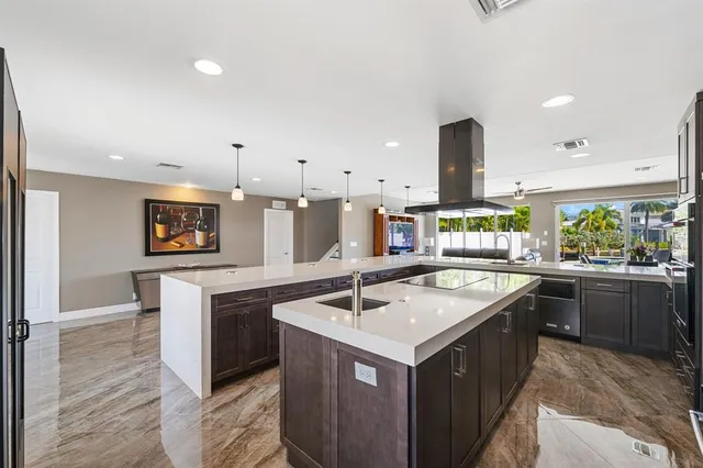 a kitchen with stainless steel appliances granite countertop a dining table chairs and sink