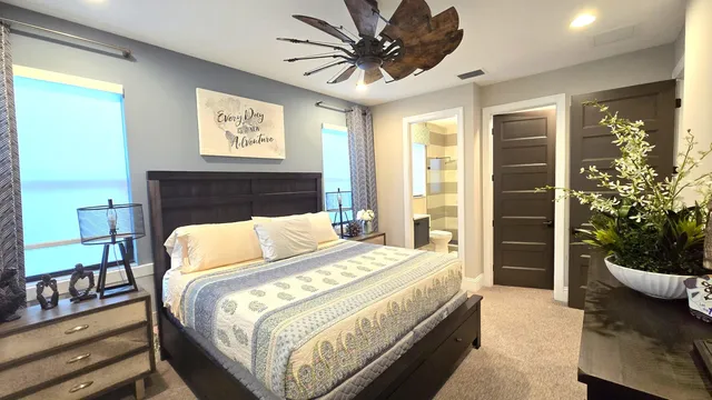 a bedroom with a bed and dresser with mirror
