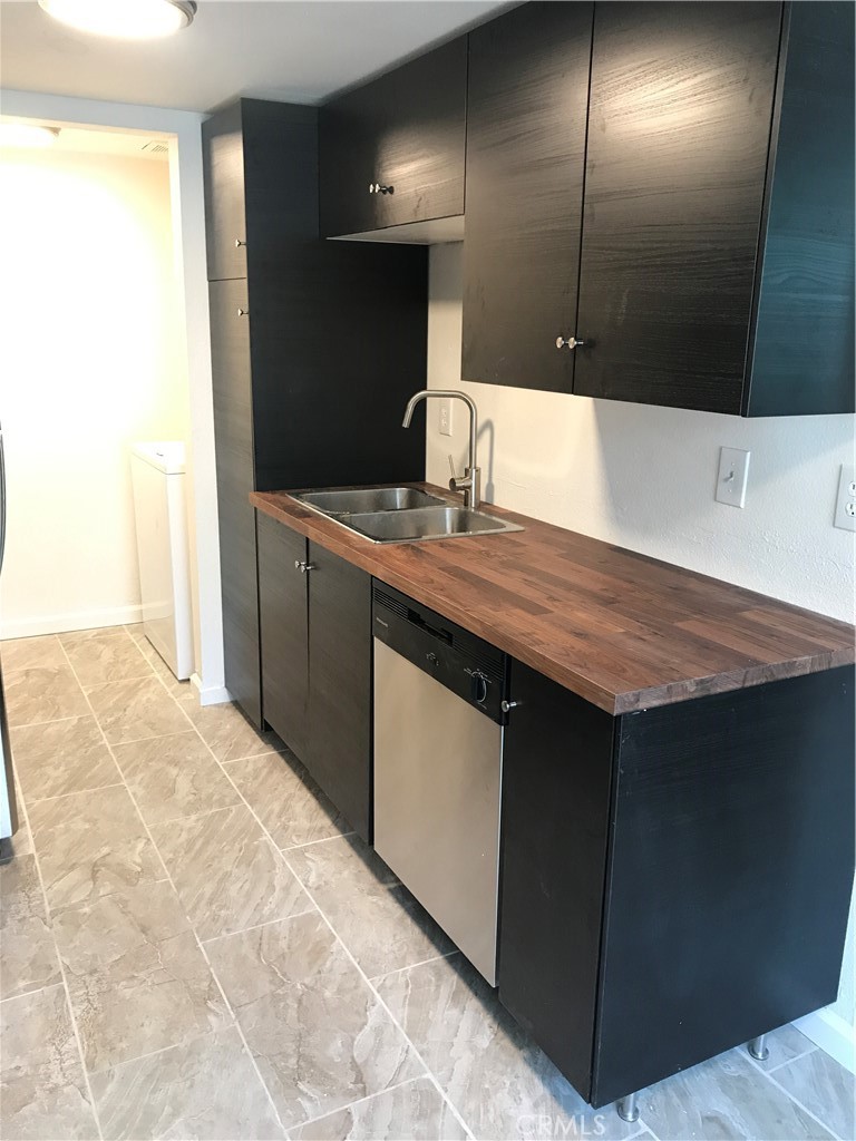 454 East Ave Q3, Unit 5 Palmdale, CA 93550 - Photo 3 of 10 a kitchen with a sink a counter space and cabinets