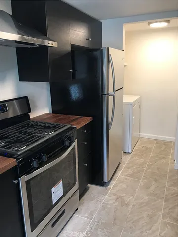 a metallic refrigerator freezer sitting in a kitchen