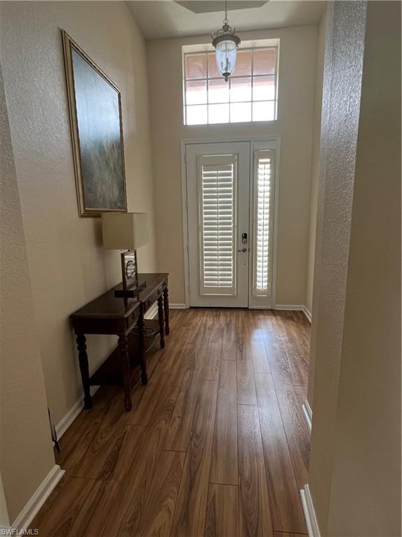 7896 Founders Circle Naples, FL 34104 - Photo 2 of 18 wooden floor in an empty room with a window