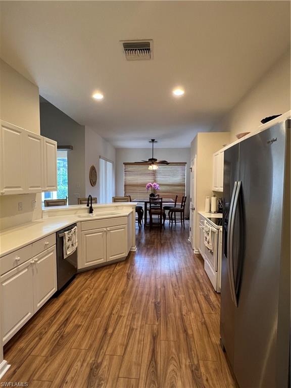 7896 Founders Circle Naples, FL 34104 - Photo 6 of 18 a kitchen with a center island wooden floor stainless steel appliances and cabinets