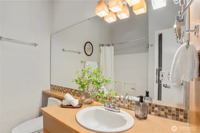 a bathroom with a sink a toilet and a mirror