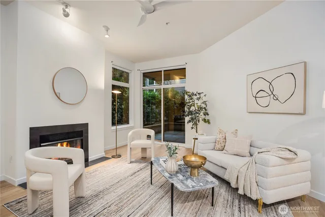 a living room with furniture a fireplace and a floor to ceiling window
