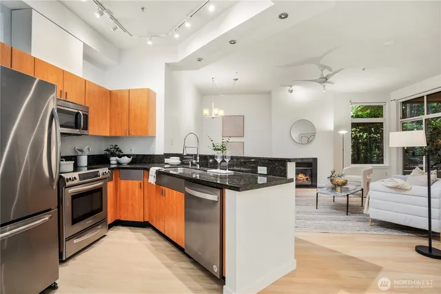 a kitchen with stainless steel appliances granite countertop a stove top oven a sink dishwasher and a refrigerator