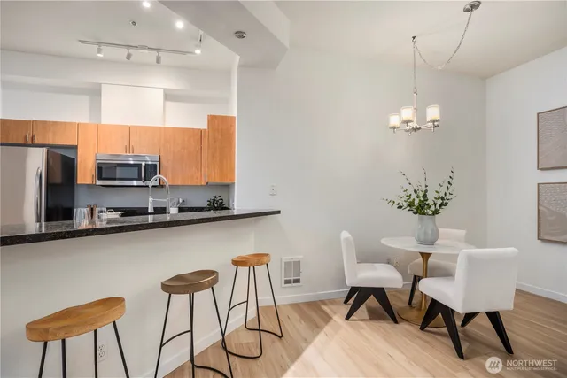 a dining room filled chandelier and kitchen view