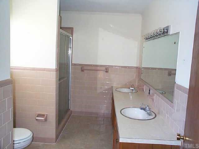 8898 Durham Road Timberlake, NC 27583 - Photo 5 of 10 a bathroom with a granite countertop sink toilet a mirror and shower