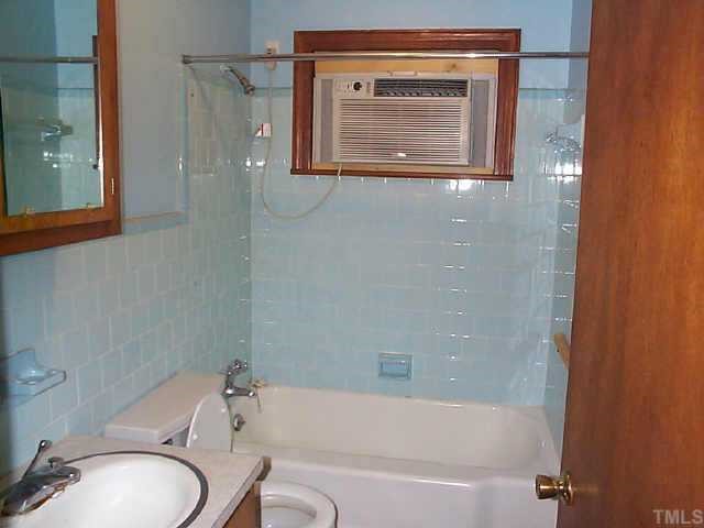 8898 Durham Road Timberlake, NC 27583 - Photo 6 of 10 a bathroom with a granite countertop toilet sink and bathtub