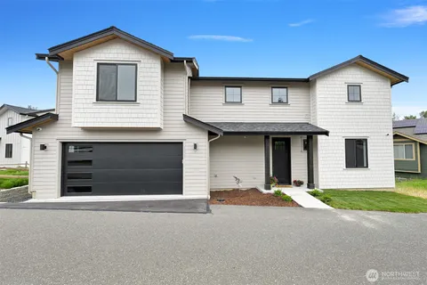 a front view of a house with a yard and garage