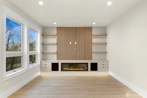 a view of an empty room with a fireplace and a window
