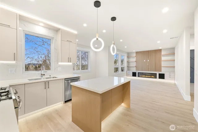 a large kitchen with stainless steel appliances kitchen island a large counter top and a wooden floors